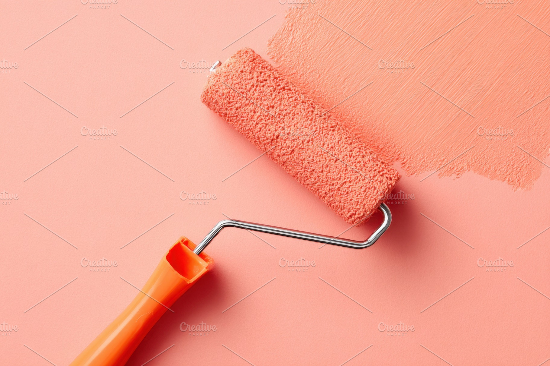 Close-up of a paint roller applying peach color on a wall, an Arts & Entertainment Photo by AlyaAnd