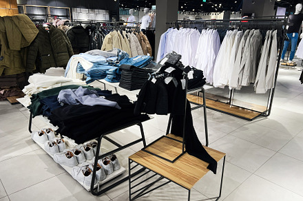 Modern retail clothing shop interior with casual and formal apparel displayed, a Photo by AS photostudio