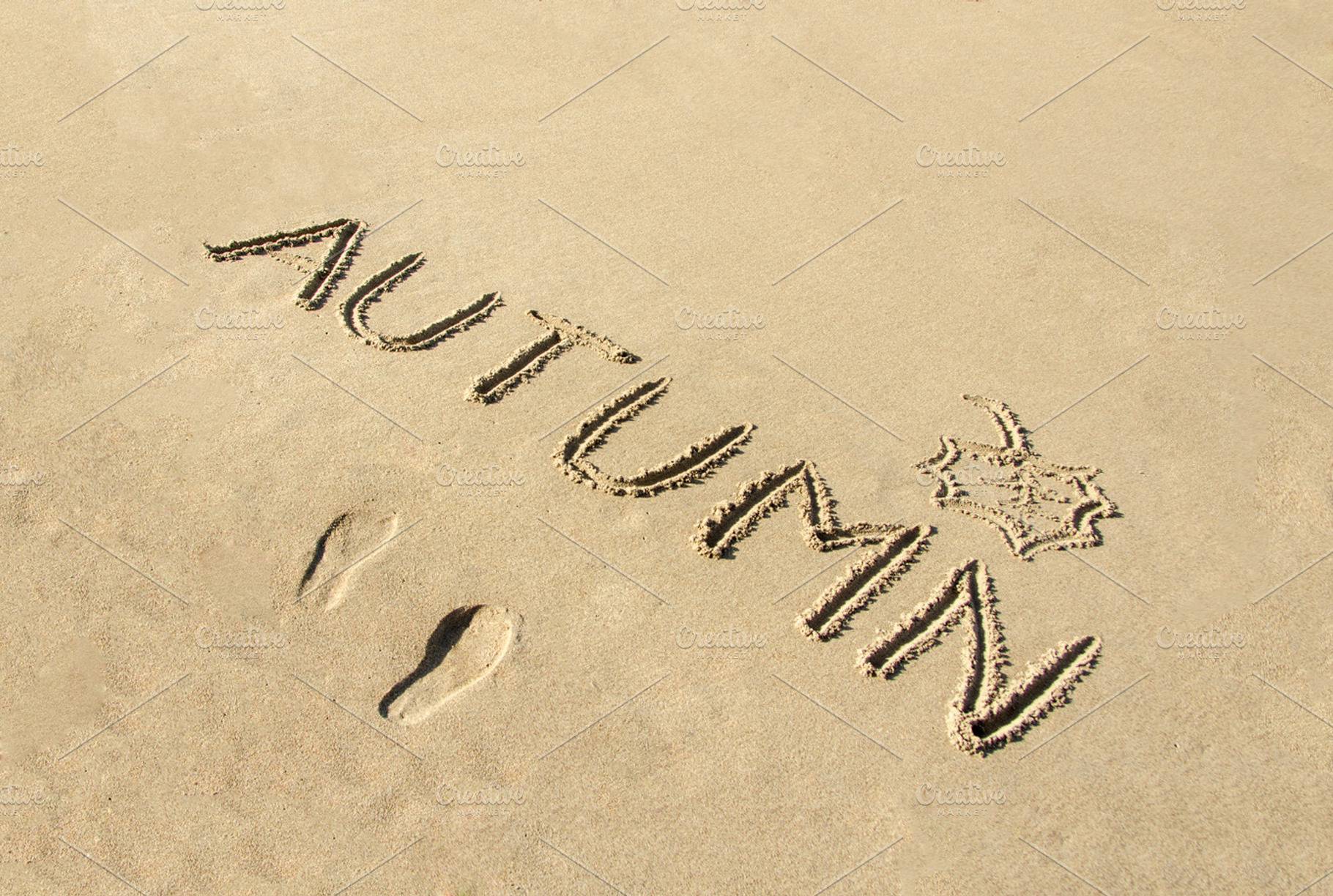 Autumn word written on beach sand