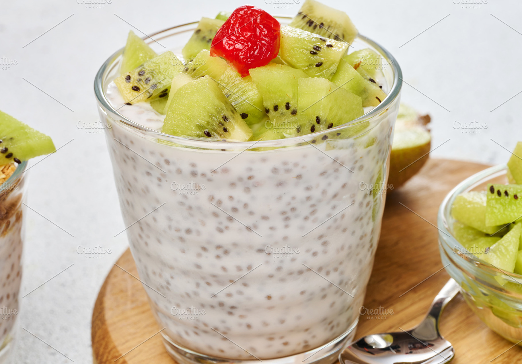 Yogurt and chia seed pudding in a glass, kiwi pieces. White tabl, a Food & Drink Photo by ndanko