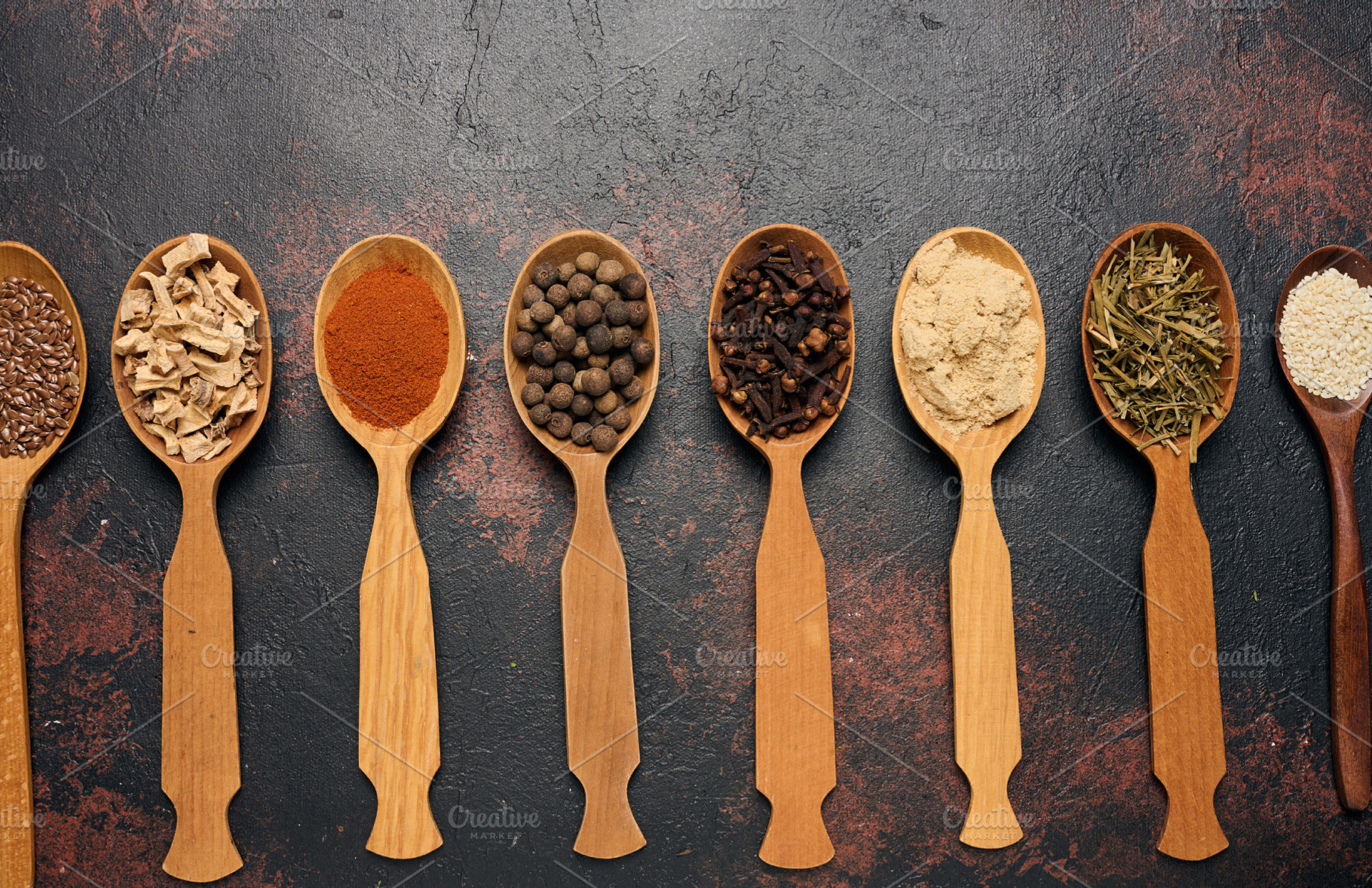 Various dried spices, seeds and roots in wooden spoons arranged, a Food & Drink Photo by ndanko