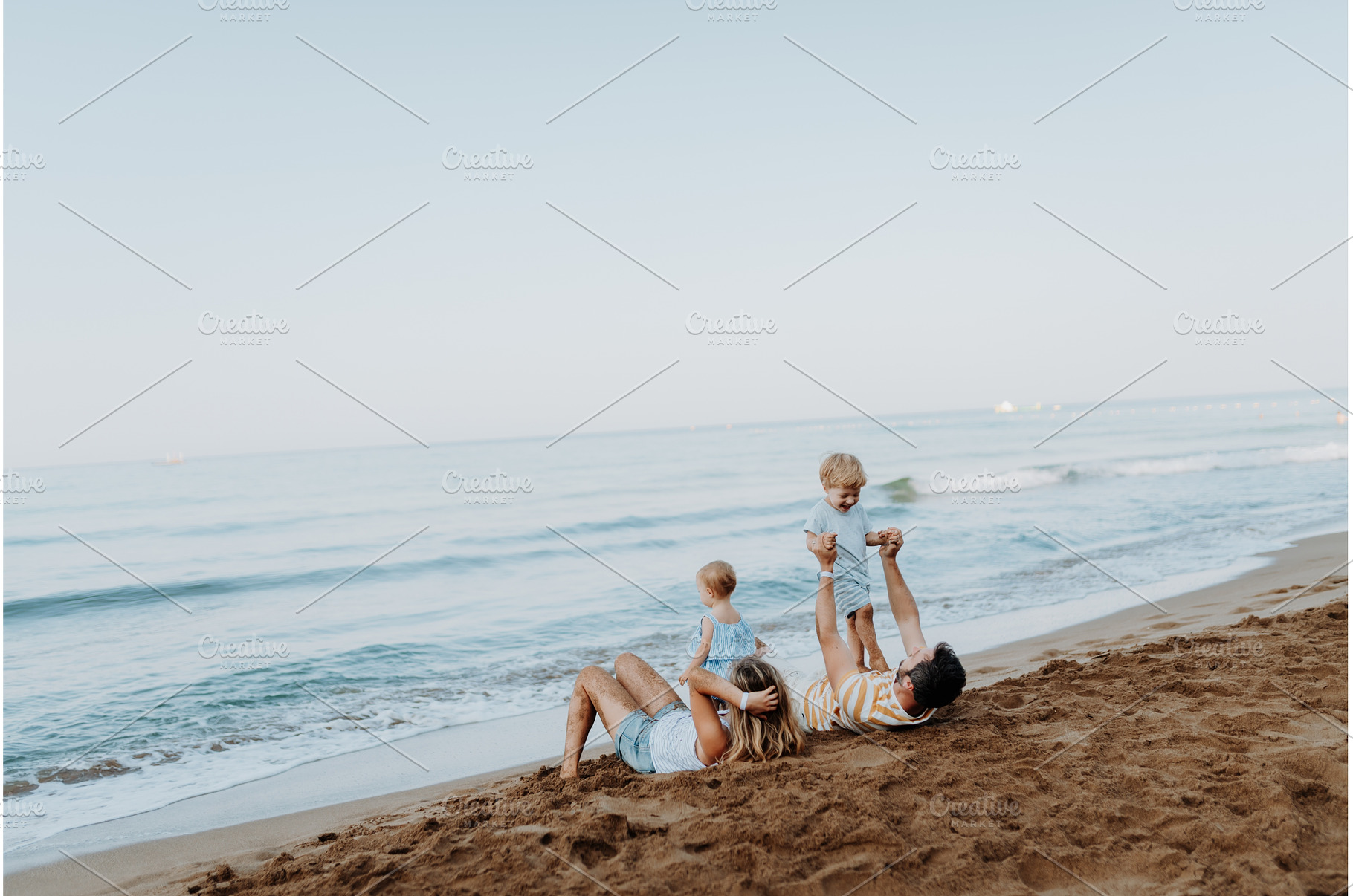 Parents lying in sand and having fun, a Person Photo by HalfPoint