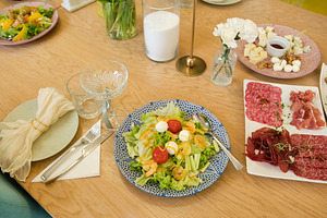 Top view of festive table setting with fresh salads, meat platter and cheese bo, a Food & Drink Photo by Rohan Photography