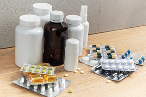 Medicine bottles and blister packs with various pills on wood, a Health & Medical Photo by Olena Rudo