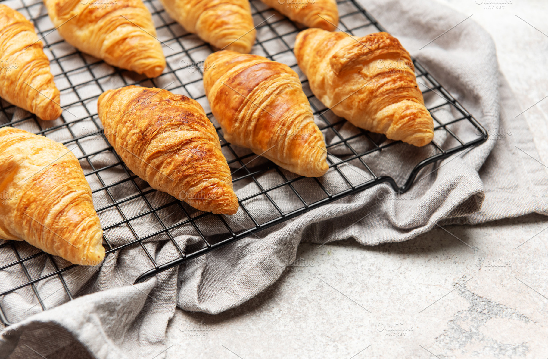 Freshly baked croissants cooling on wire rack, perfect start to, a Food & Drink Photo by Olena Rudo