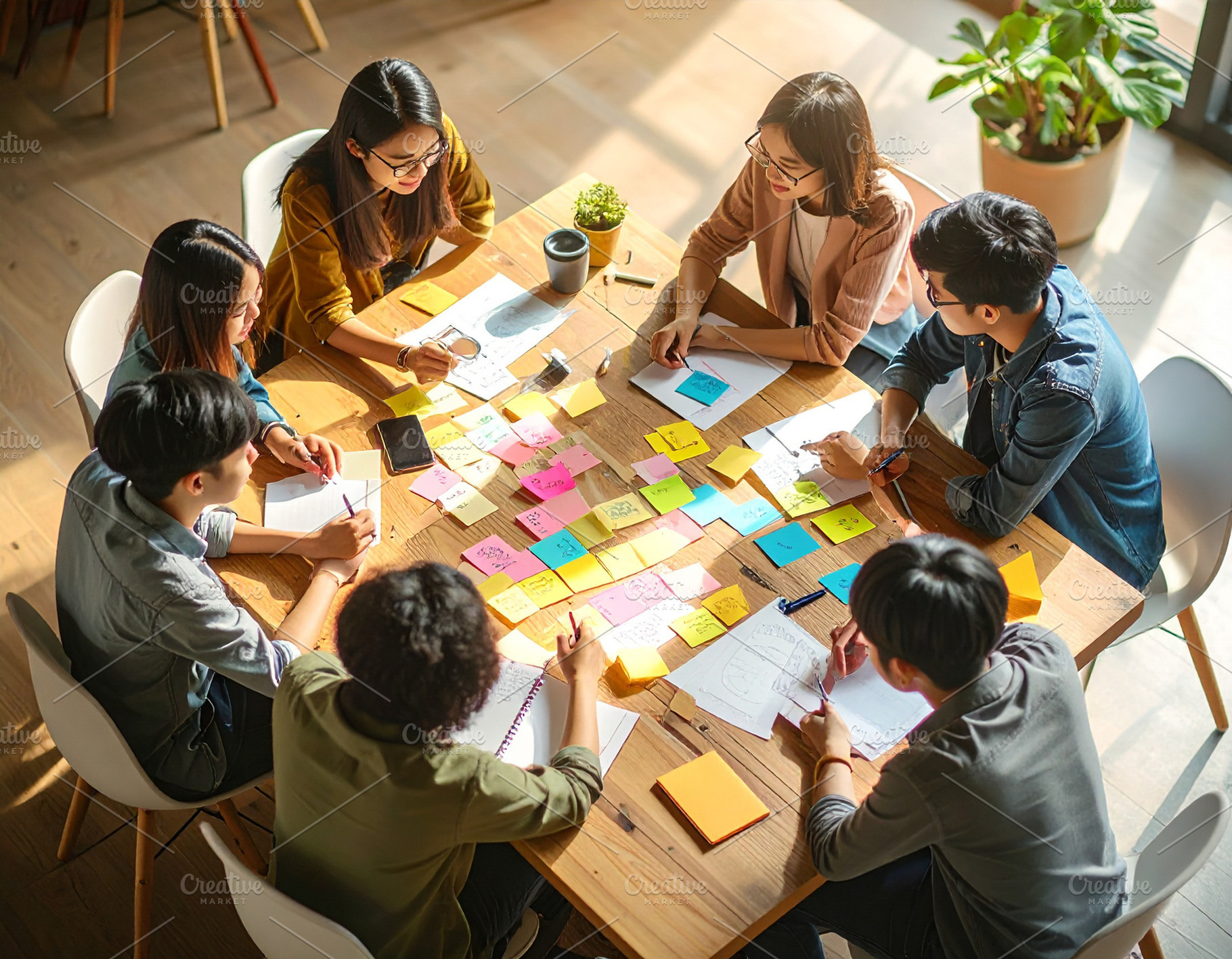 Young professionals engaged in a brainstorming session around a, a Business Photo by DanFLCreativo