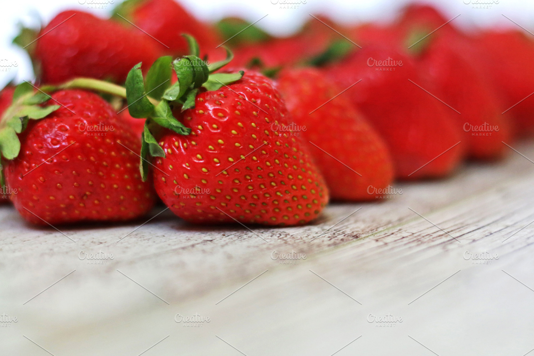Strawberries on a gray wooden back, a Food & Drink Photo by Iryna Sotnykova