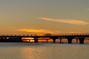 A serene sunset over a river with a bridge silhouetted against the colorful sky, a Nature Photo by Textures & Backgrounds