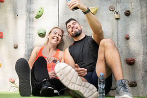 Happy fitness couple taking selfie after workout near outdoor climbing wall, a Food & Drink Photo by etorres69