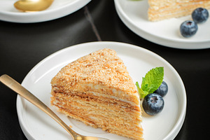 Medovik. Honey cake made from honey cakes with whipped sour cream, decorated wi, a Food & Drink Photo by Budarinphoto