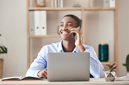 Happy businessman on a phone call while working on a laptop at the desk in his office. Corporate, professional and company manager smile while networking on mobile conversation with 5g technology, a Photo by Peopleimages.com