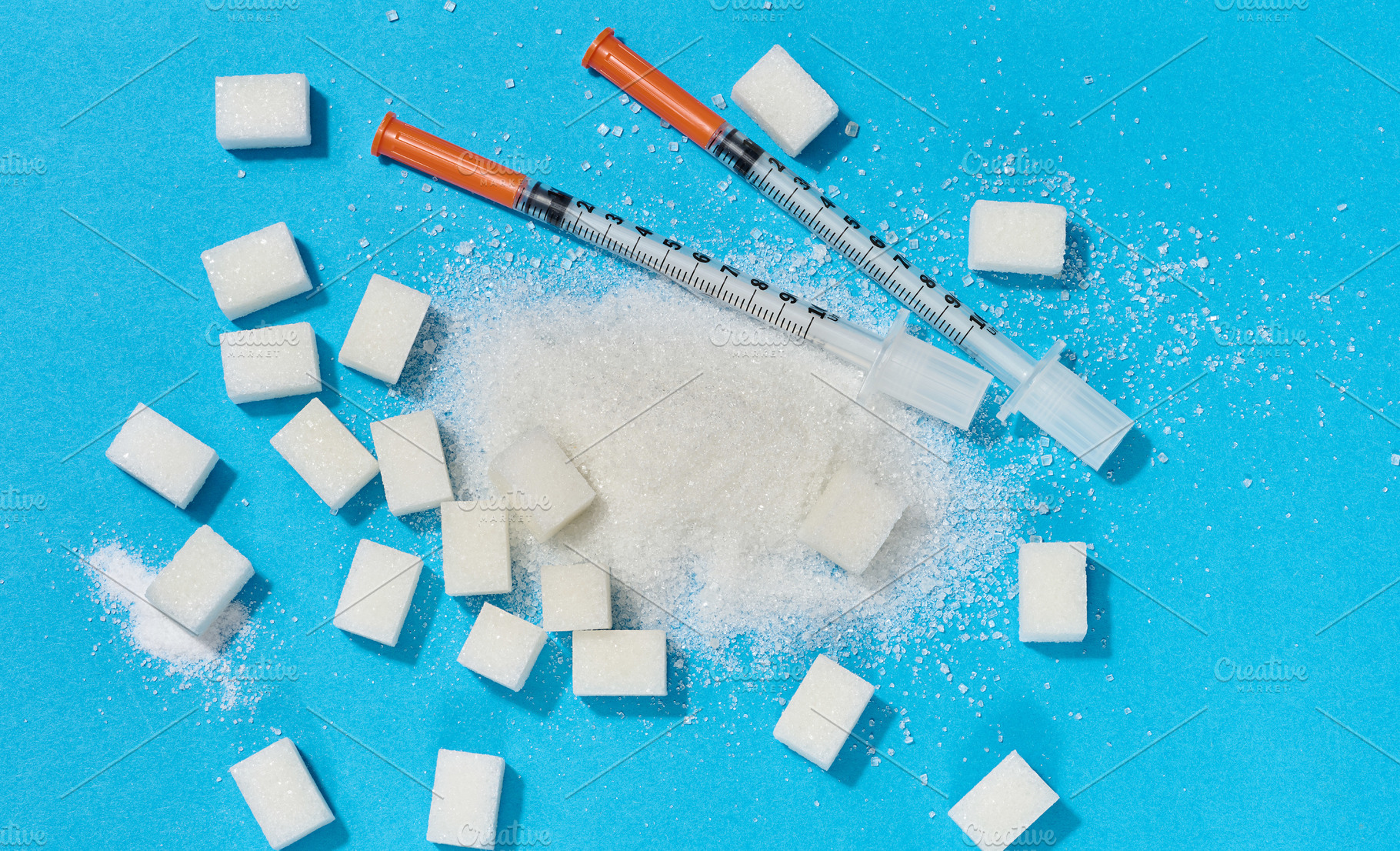 Two insulin syringes and scattered white sugar on a blue backgro, a Food & Drink Photo by ndanko