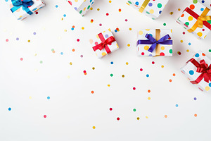 Colorful gift boxes with confetti on white background, a Holiday Photo by AlyaAnd