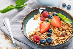 Granola bowls with berries, yogurt, nuts, and honey for breakfas, a Food & Drink Photo by Olena Rudo