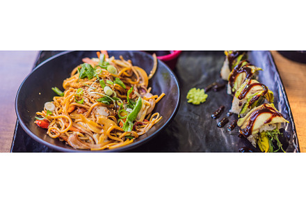 Asian noodles and sushi in black, a Food & Drink Photo by Elizaveta Galitskaya