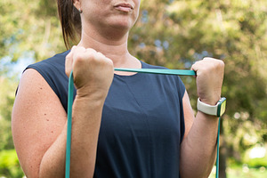 Young woman doing resistance band bicep exercise, a Person Photo by etorres69