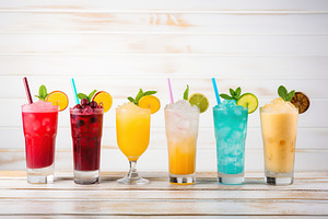 Different alcohol cocktails on wooden background, a Food & Drink Photo by AlyaAnd