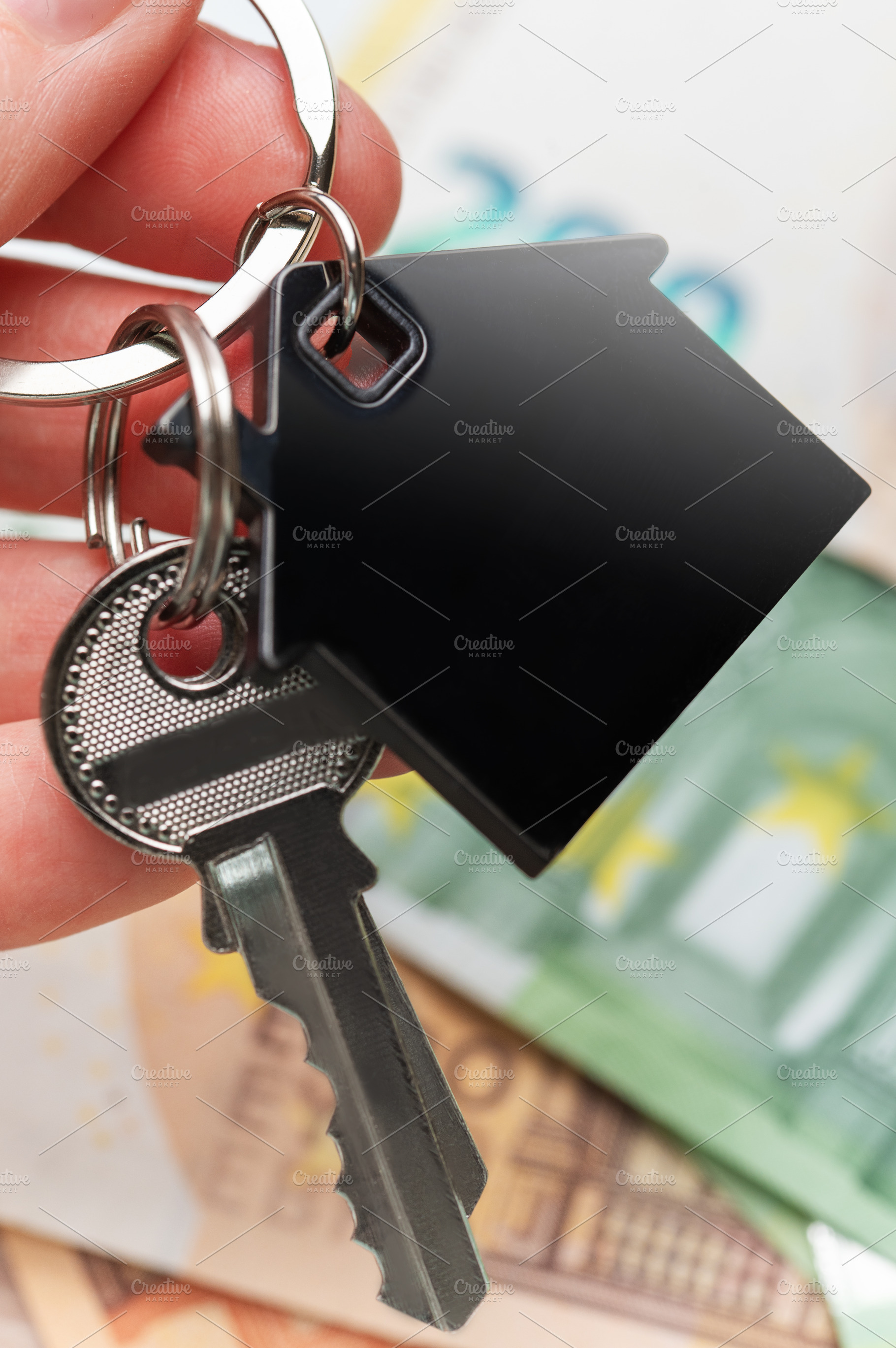 Hand holding house keys over euro currency, a Business Photo by Olena Rudo
