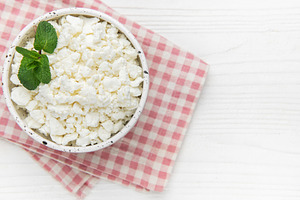 Cottage cheese in bowl with mint leaves, a Food & Drink Photo by Olena Rudo