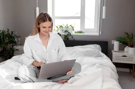Girl sits on the bed with laptop, a Photo by Lenor4ik