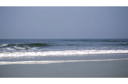 Calm ocean waves gently lap at a, a Nature Photo by Media Whale Stock
