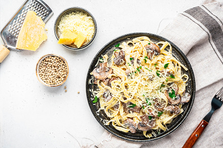 Tagliatelle pasta with mushrooms served on plate with parsley an, a Food & Drink Photo by 5PH