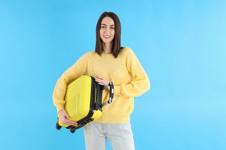 Attractive woman with travel bag on blue background, a Person Photo by AtlasStudio PRO