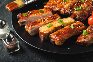 Hot grilled spare ribs from a summer BBQ served on a plate with, a Food & Drink Photo by Budarinphoto