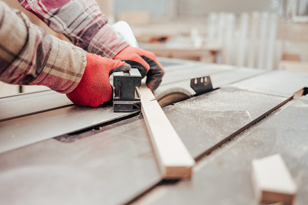 Carpenter cuts plywood on a circular, a Photo by borodai94