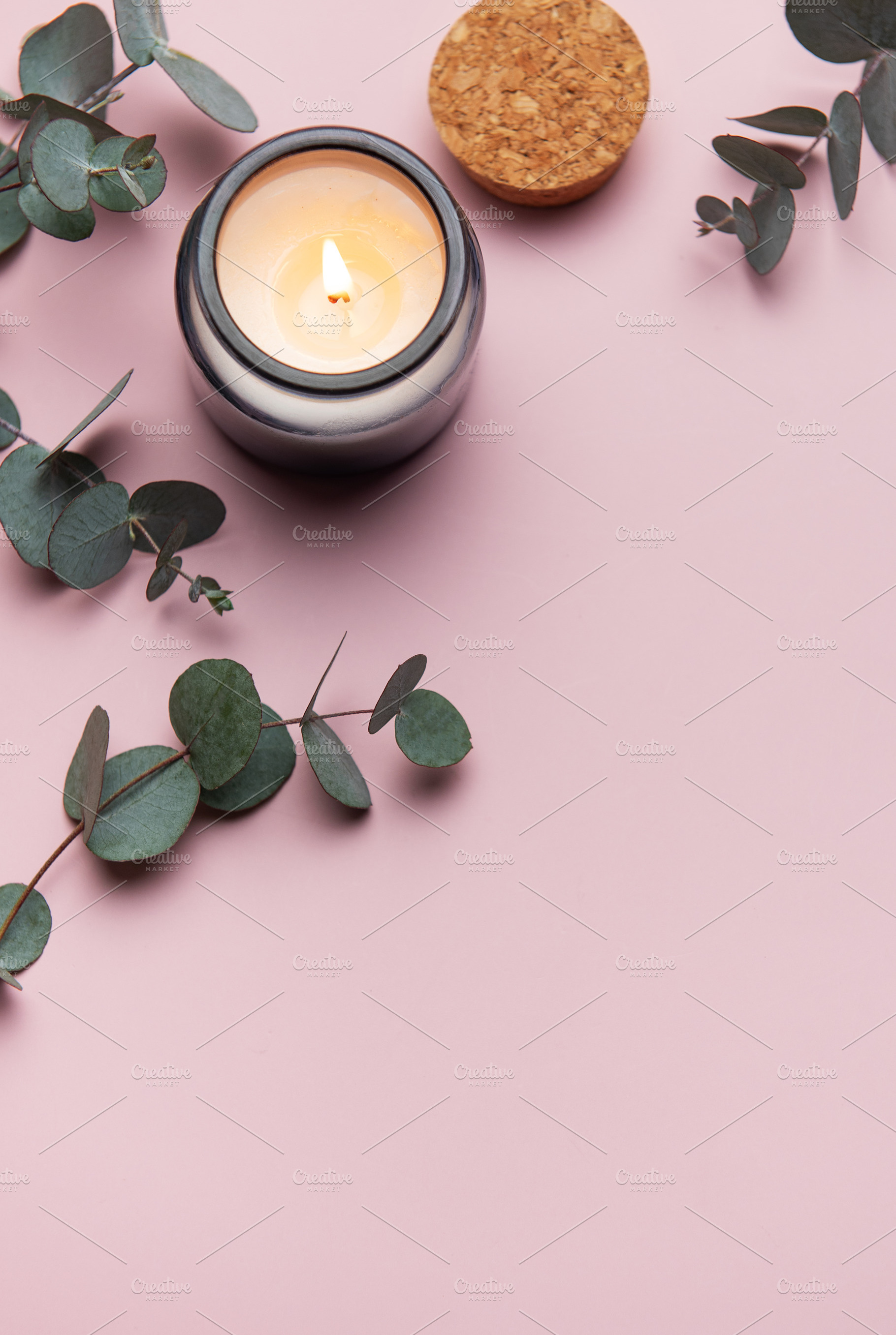 Burning aromatic candle with eucalyptus branches on pink backgro, a Health & Medical Photo by Olena Rudo