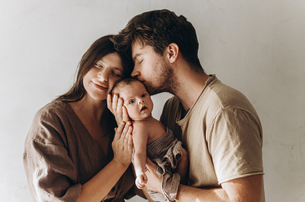 Happy mother and father hugging and kissing little baby son. Hap