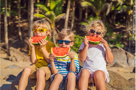 Children eat watermelon on the beach, a Person Photo by Elizaveta Galitskaya
