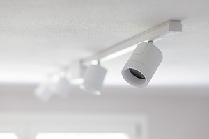 White spotlights hanging from ceiling illuminating bright room, an Architecture Photo by Antonio Gravante Market