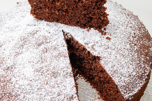 Delicious caprese cake with icing sugar resting on glass plate, a Food & Drink Photo by Antonio Gravante Market
