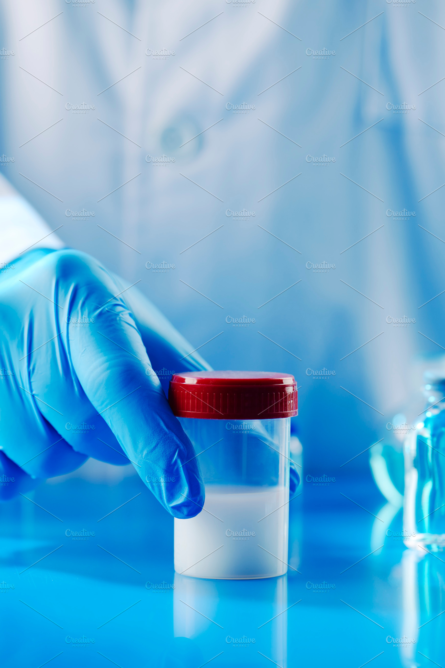 man in a laboratory with a container with semen, a Photo by Nito