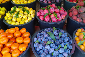 Outdoor market with barrels of fresh fruit, a Food & Drink Photo by DanFLCreativo