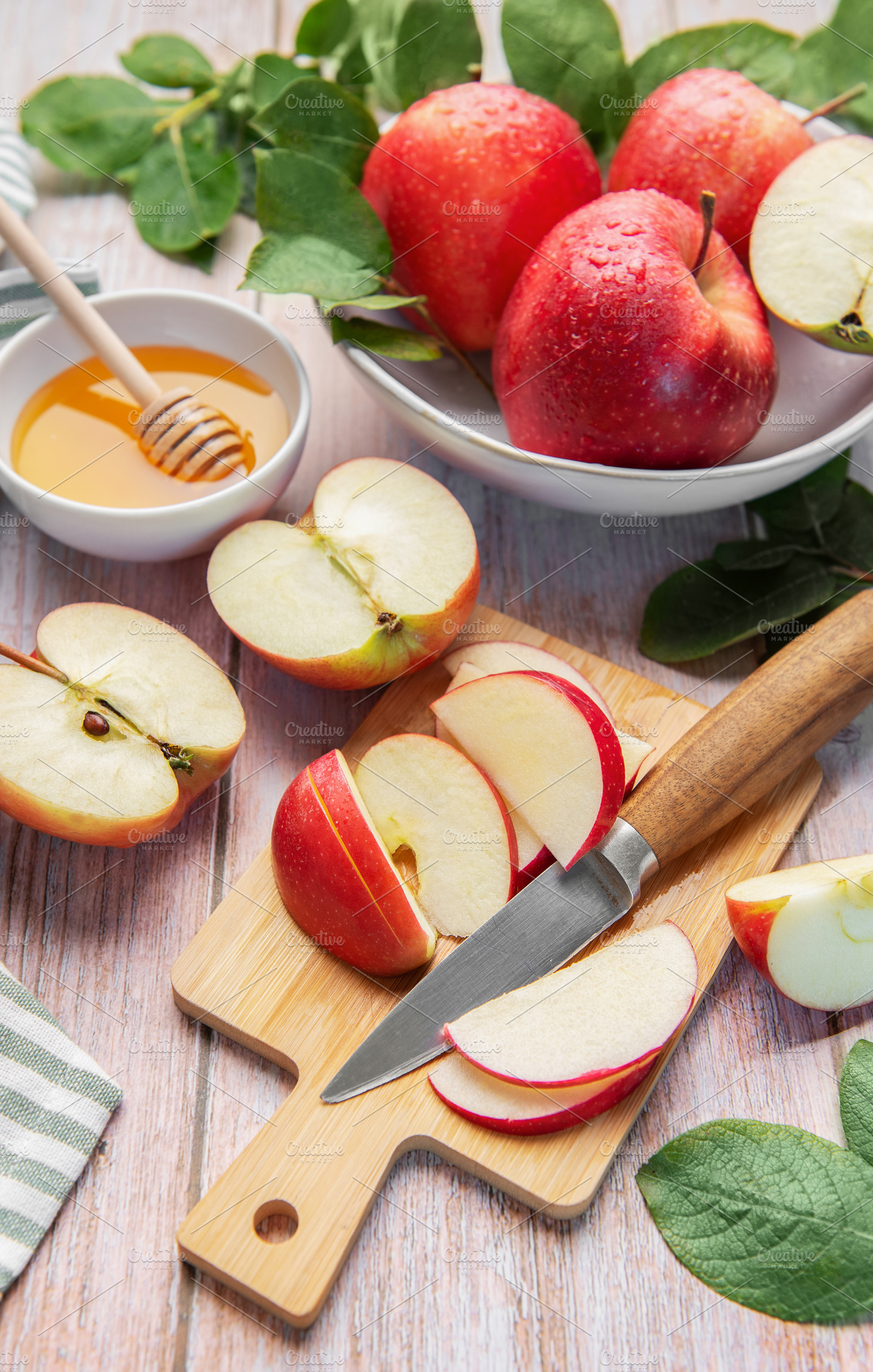 Sliced red apples and honey on wooden table, a Food & Drink Photo by Olena Rudo