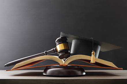 Concept of education judgment with book, mace and mortarboard