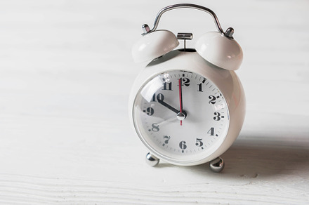 White clock on wooden table. Object and electronics concept., a Technology Photo by Ministocker