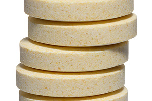 Vertical stack of large round pills of light yellow color, isola, a Food & Drink Photo by ndanko