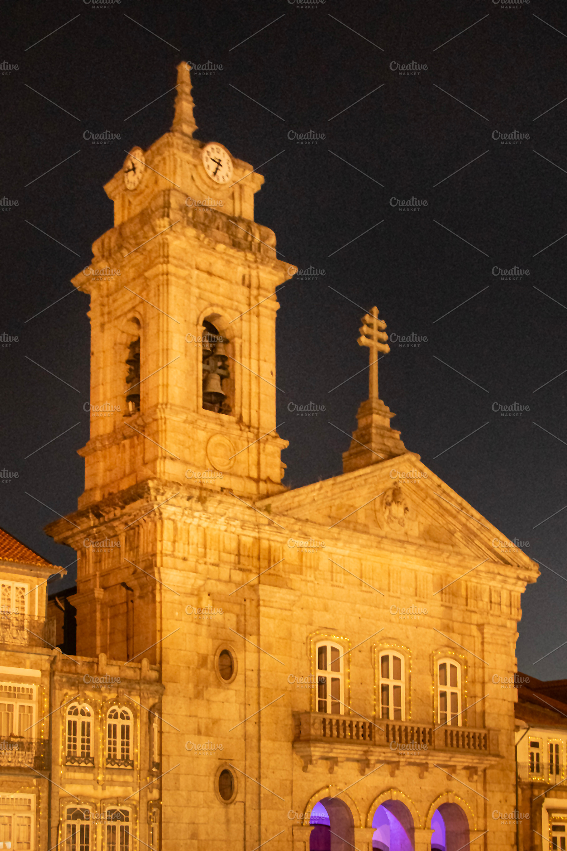 Illuminated church tower and historic buildings in main square,, a Photo by DanFLCreativo