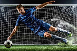 Soccer player kicking ball mid-air in goal, a Sports & Recreation Photo by Davizro's Market