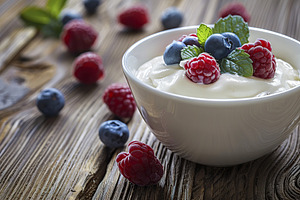 Bowl with white yogurt and ripe berries on wooden table, a Food & Drink Photo by AlyaAnd