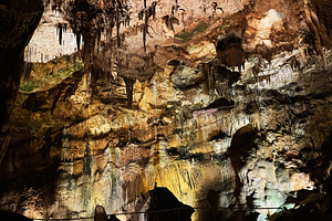 Illuminated stalactites and stalagmites within in Mira de Aire, Portugal., a Photo by AS photostudio