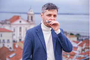 Man plays harmonica outdoors in city