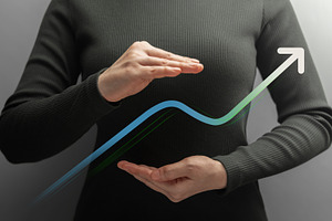 Businesswoman shields a rising graph between her hands, a Photo by salmon.black