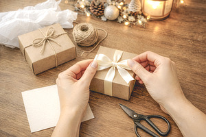 Hands wrapping Christmas gift box, a Photo by rarrarorro