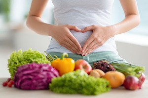 Woman making heart shape over stomach with fresh produce, a Food & Drink Photo by AlyaAnd