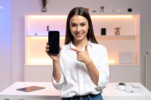 Woman content creator standing in a modern studio holding up a s, a Person Photo by DanFLCreativo