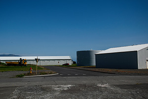 Industrial area with buildings and blue sky in Akranes, Iceland, a Photo by AS photostudio